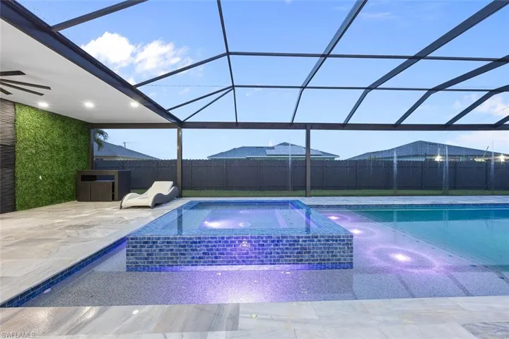 View of swimming pool featuring an in ground hot tub, a patio area, glass enclosure, and a fenced in pool