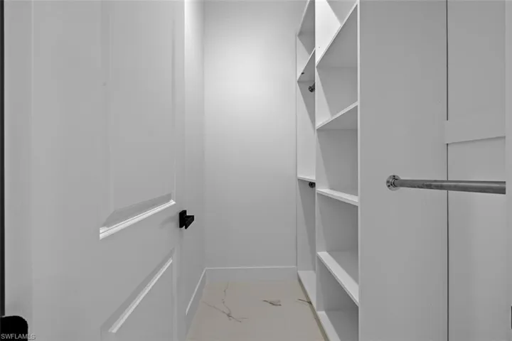 Walk in closet with marble finish floor