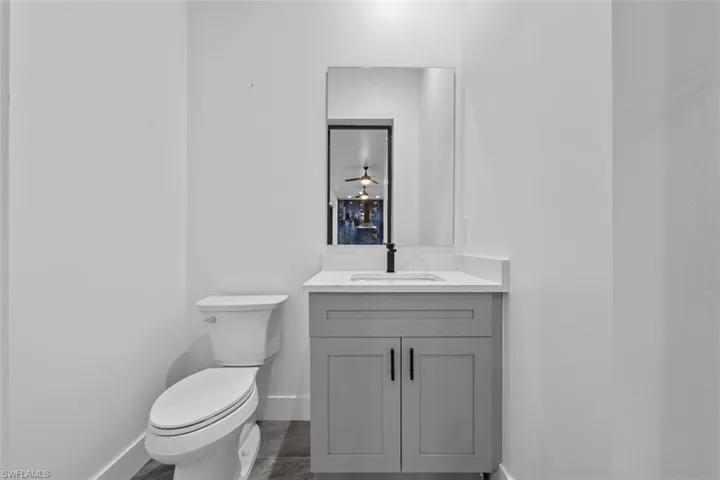 Pool Half-Bathroom with baseboards, vanity, and toilet