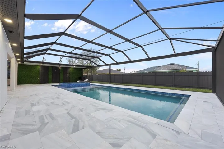 View of swimming pool with a patio, a lanai, a fenced in pool, and fence