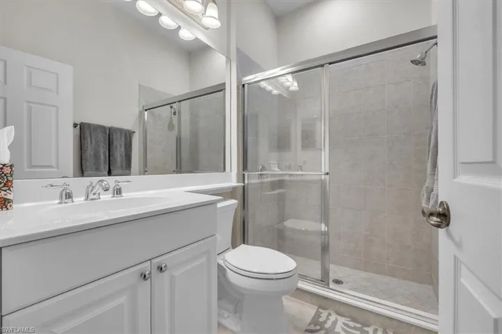 Vanity with integrated sink, chrome fixtures, and a large wall-mounted mirror