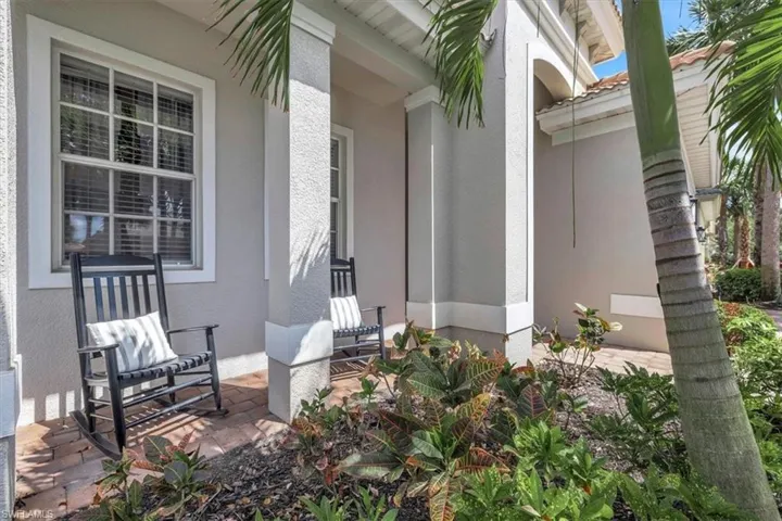 Entry porch featuring decorative brick flooring, stucco exterior, and prominent structural columns