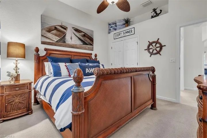 Recessed ceiling feature, neutral wall paint, ceiling fan, carpeted flooring, double closet doors