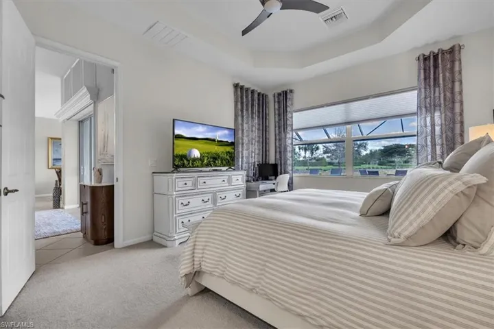 Recessed lighting, ceiling fan, tray ceiling, large window with blinds, and carpeted flooring