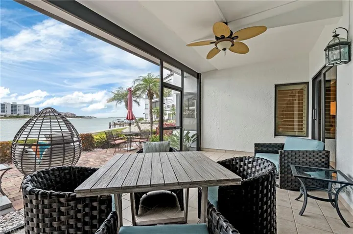 Screened-in extended lanai with ceiling fan and a water view.