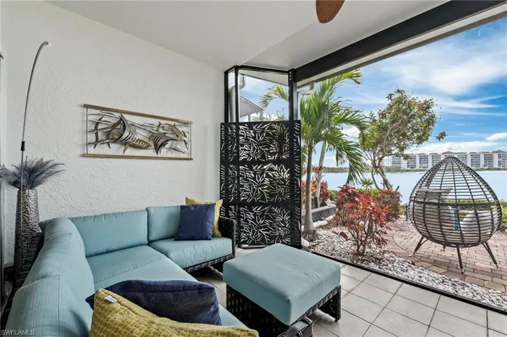 Screened-in lanai with water views. Extended coverage for perfect sitting area featuring ceiling fan and light tile patterned floors