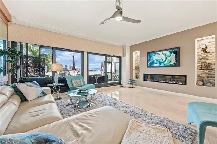 Living room with electric "color controlled" fireplace, built-in display shelves with stone background. Water views.