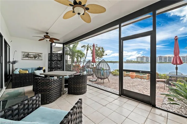 Screened-in, extended lanai with ceiling fan and a water view. Sitting and dining areas.