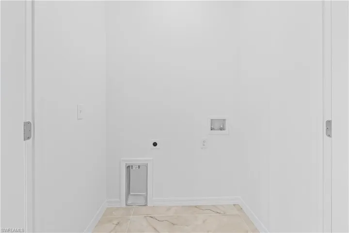 Washroom featuring electric dryer hookup, hookup for a washing machine, and light marble finish flooring