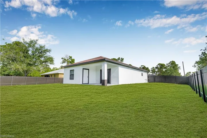 Rear view of property with a fenced backyard and stucco siding