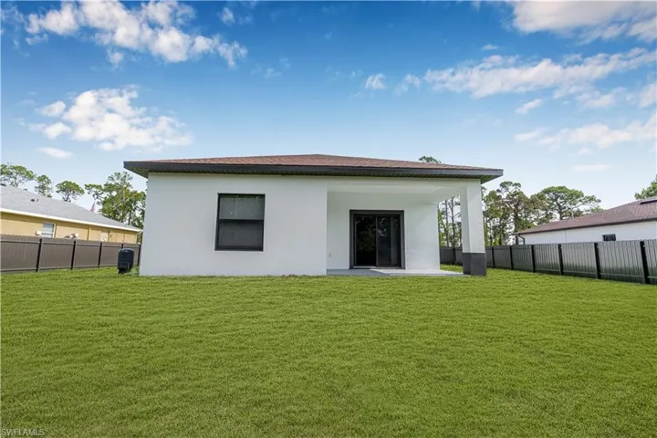 Back of property with a fenced backyard, stucco siding, and a patio