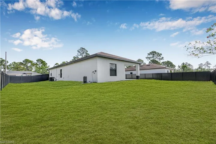 Back of property with stucco siding and a fenced backyard