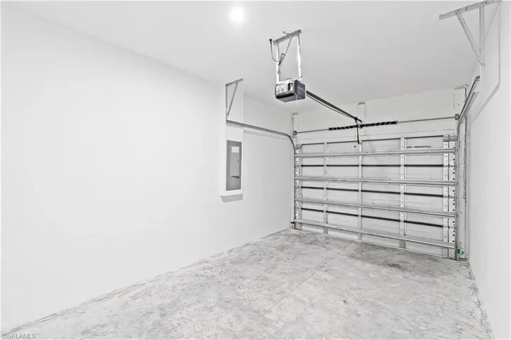 Garage with electric panel and a garage door opener