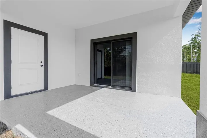 Property entrance with a patio area and stucco siding