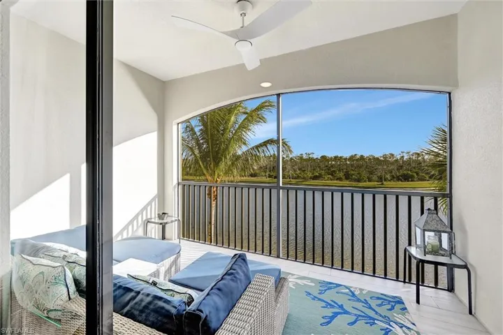 Sunroom with a water view and view of scattered trees