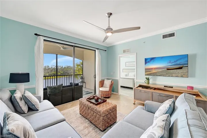 Tiled living area with ornamental molding and ceiling fan