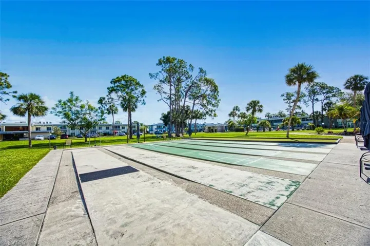 Surrounding community featuring shuffleboard and a lawn