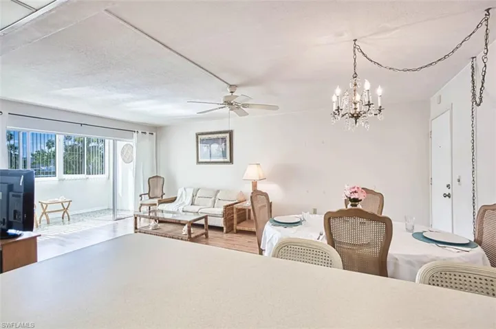 Living area featuring wood finished floors, a chandelier, and ceiling fan