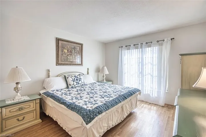 Bedroom with newer laminate floors and a textured ceiling
