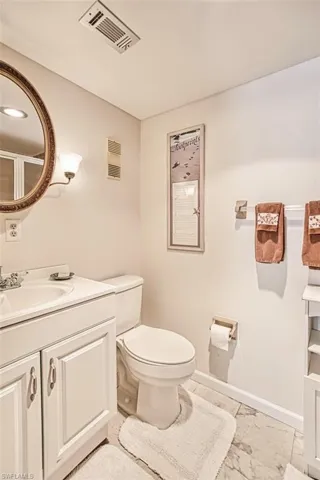 Primary bathroom featuring marble look tiles and vanity