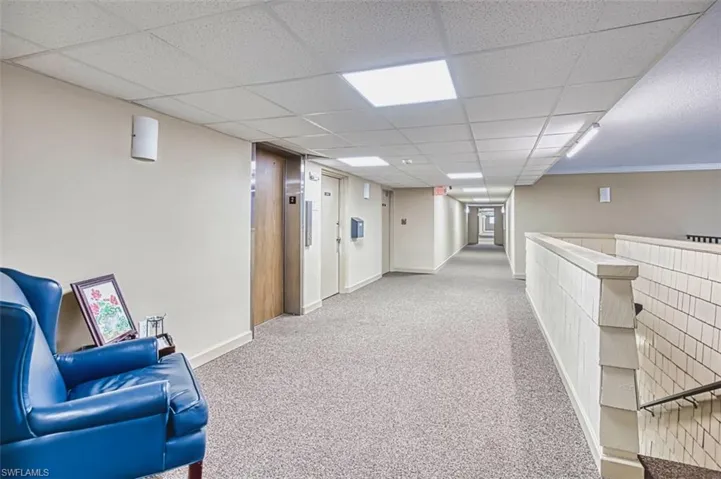 Hall featuring carpet flooring, elevator, and a drop ceiling