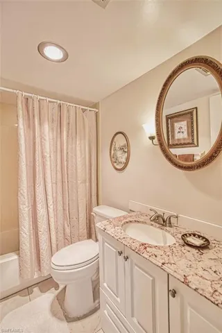 Guest Bathroom featuring vanity, shower / bath combo, and tile patterned flooring