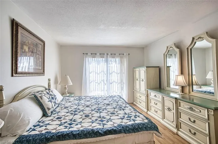 Bedroom with light wood-style floors and a textured ceiling