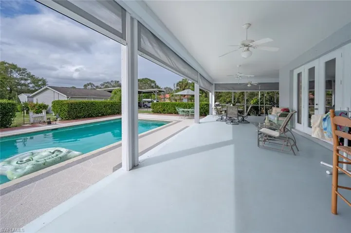 View of swimming pool with a patio, ceiling fan, and french doors