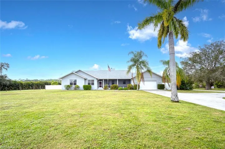 Single story home with a garage and a front yard