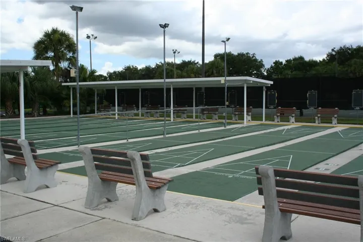 Multiple shuffleboard courts featuring green playing surfaces with white markings