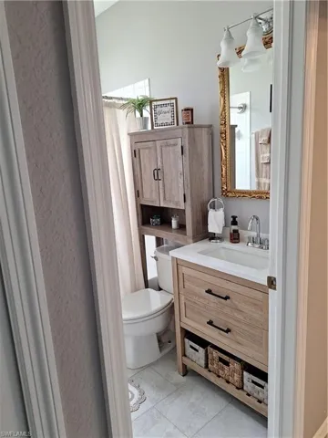 Bathroom vanity featuring a vessel sink, single-handle faucet, and wood-finish cabinetry