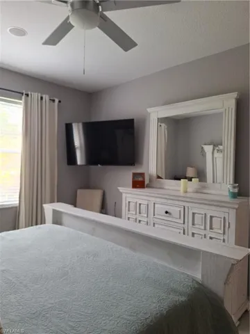 Room featuring a ceiling fan with integrated lighting, recessed lighting, and a window with blinds and drapery