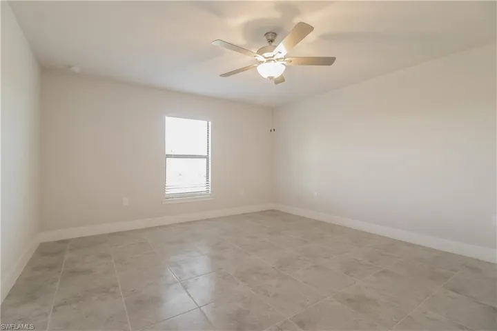 Spare room featuring ceiling fan and light tile floors