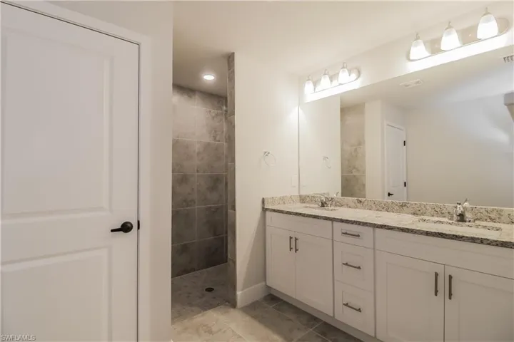 Bathroom featuring tile floors, dual sinks, and large vanity