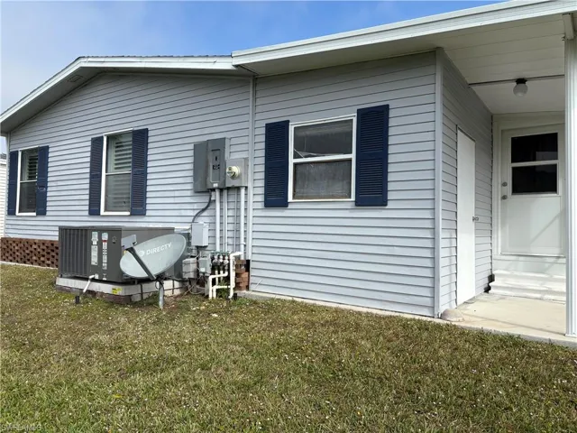Rear view of property with a yard and central air condition unit