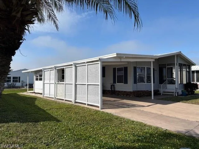 View of home's exterior with a yard and a carport