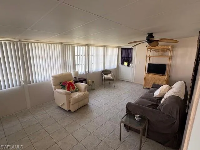 Living room featuring light tile patterned flooring and a ceiling fan