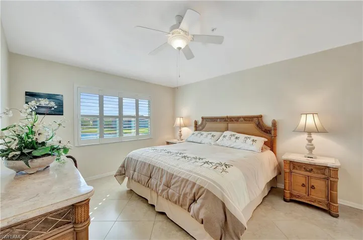 Tiled bedroom featuring ceiling fan