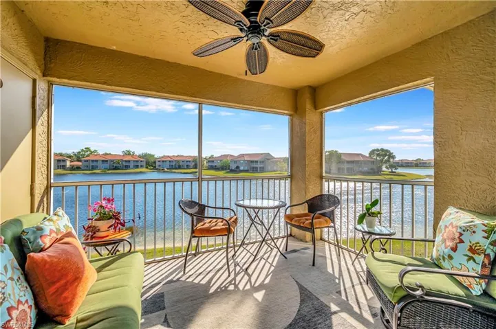 Sunroom featuring a wealth of natural light, a water view, and ceiling fan