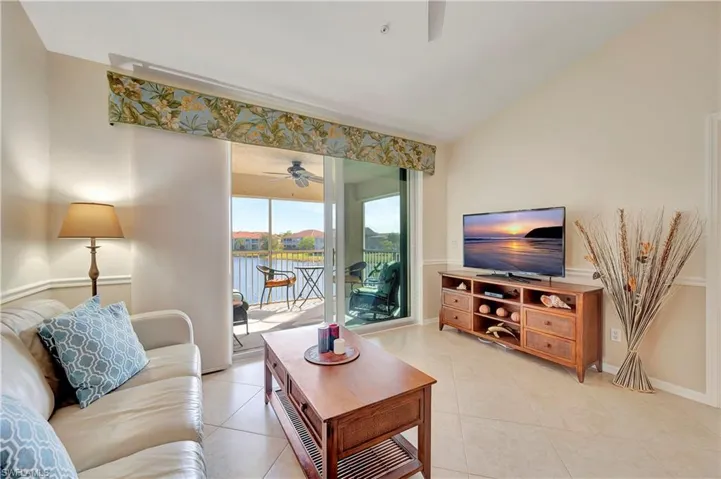 Tiled living room featuring vaulted ceiling and ceiling fan