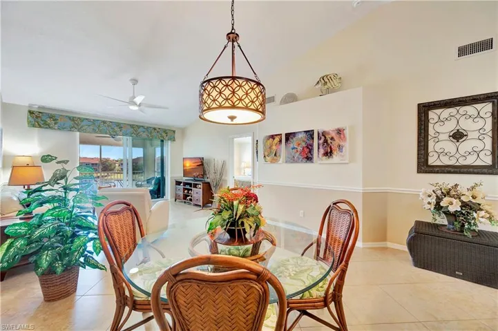Tiled dining space with ceiling fan and vaulted ceiling