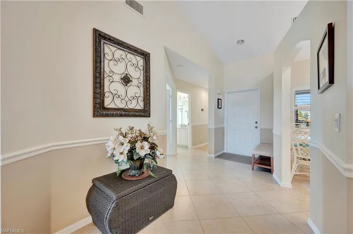 Hall featuring light tile patterned floors and high vaulted ceiling