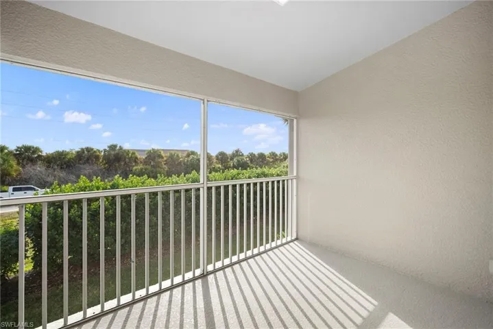 Balcony with a sunroom and view of scattered trees