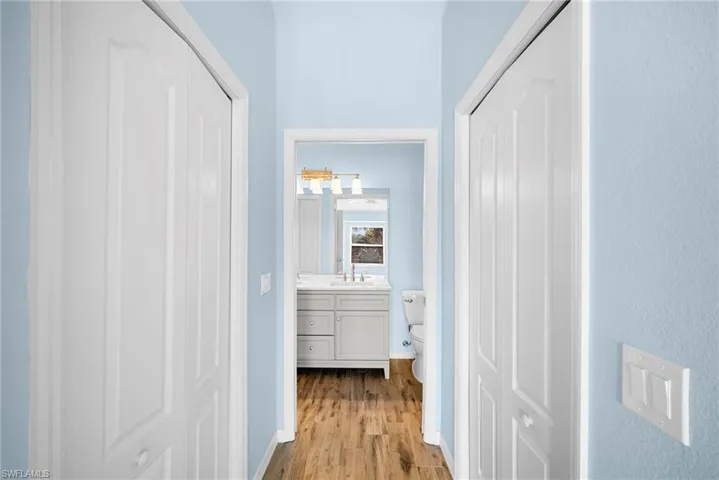 Corridor featuring light wood-type flooring and baseboards