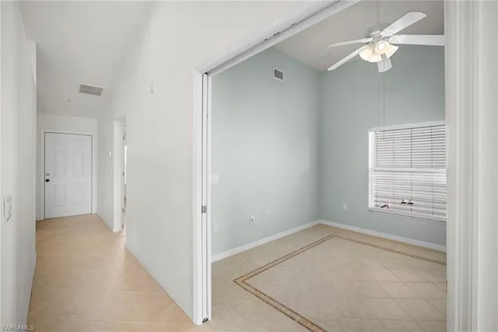 Unfurnished room with light tile patterned flooring, a ceiling fan, and lofted ceiling