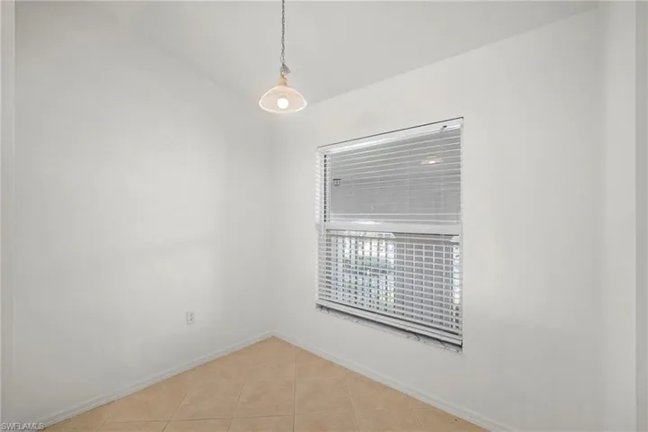 Spare room with light tile patterned flooring and baseboards
