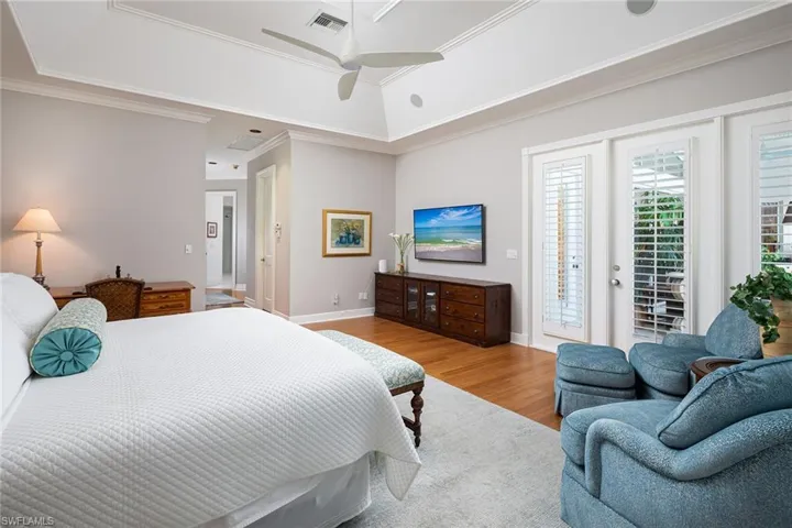 Bedroom with access to exterior, light wood-type flooring, a ceiling fan, and ornamental molding
