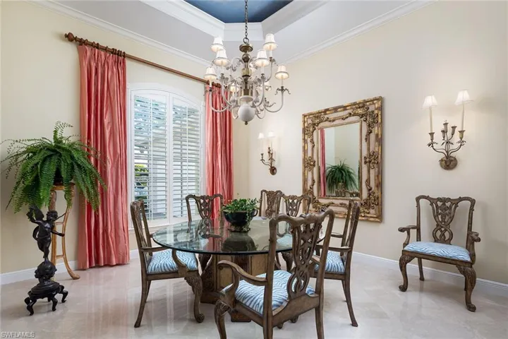 Dining space with ornamental molding and a chandelier