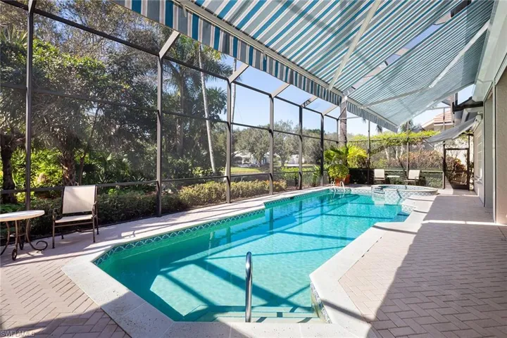 View of swimming pool with a patio area, a lanai, a pool with connected hot tub, and a sunroom