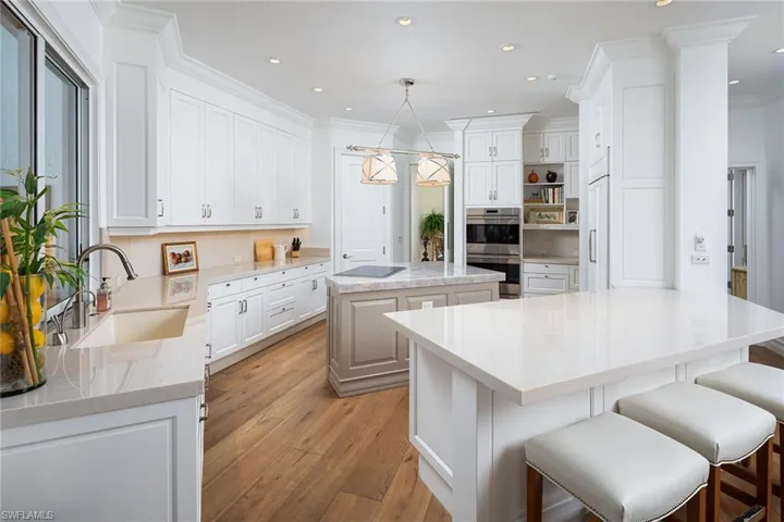 Kitchen featuring a kitchen island, light wood-style floors, decorative light fixtures, white cabinetry, and recessed lighting